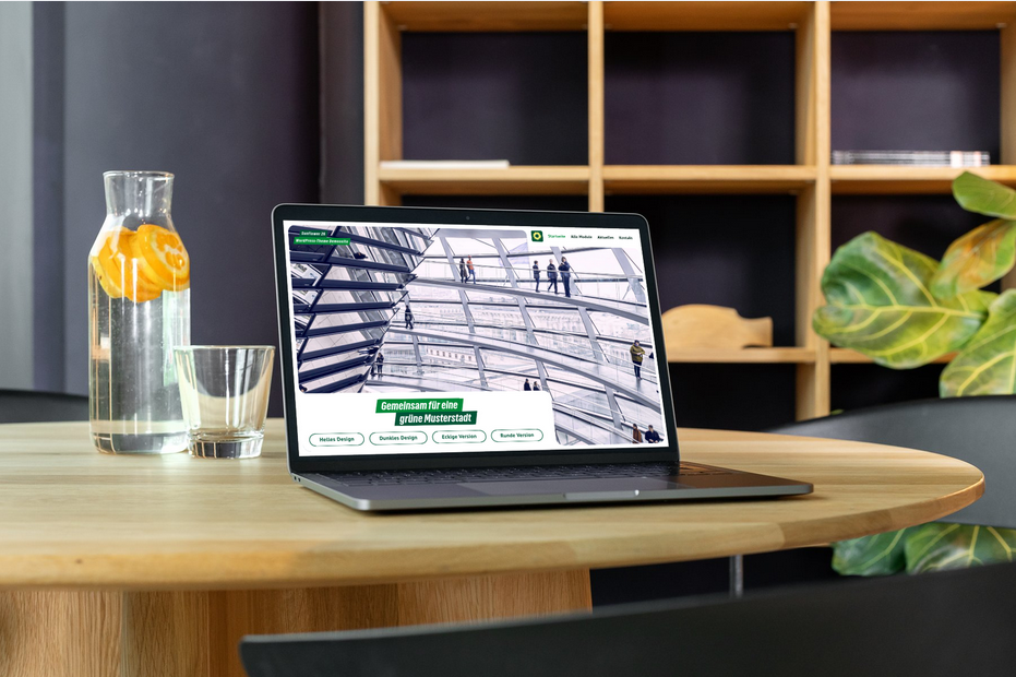 Laptop mit Displayansicht einer Website im Grünen CMS.